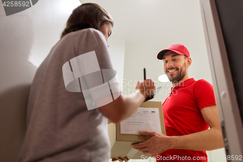 Image of deliveryman and customer with parcel boxes at home