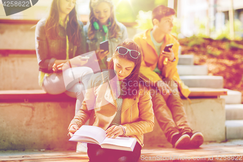 Image of high school student girl reading book outdoors