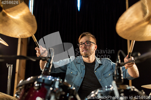 Image of male musician playing drums and cymbals at concert