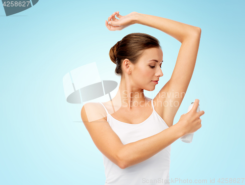 Image of woman with antiperspirant deodorant over blue