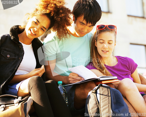 Image of cute group of teenages at the building of university with books 