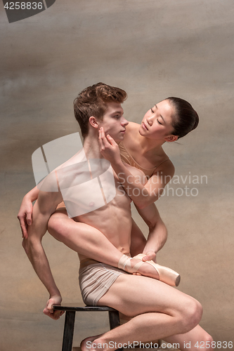 Image of Couple of ballet dancers posing over gray background