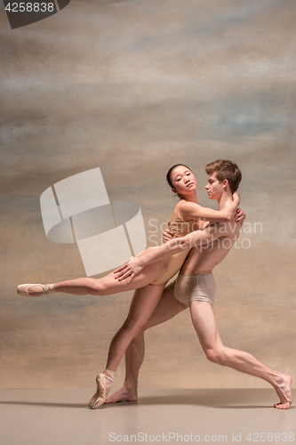 Image of Couple of ballet dancers posing over gray background