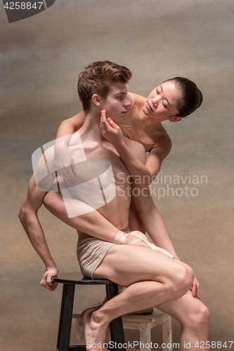 Image of Couple of ballet dancers posing over gray background