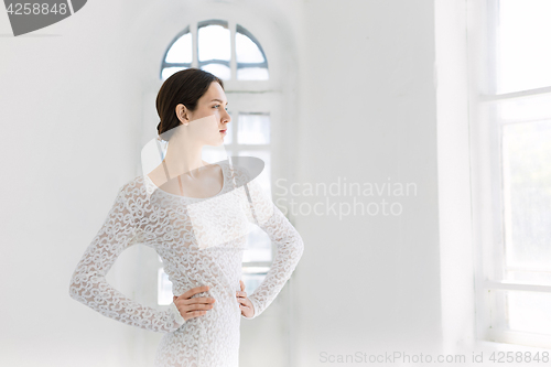 Image of Young and incredibly beautiful ballerina is posing and dancing in a white studio