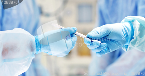 Image of close up of hands with scalpel at operation