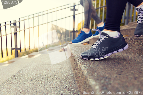 Image of close up of feet running downstairs in city