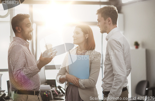 Image of happy business team drinking coffee at office