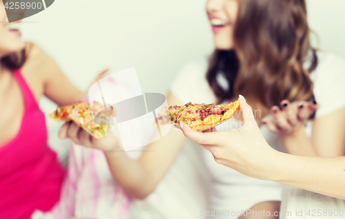 Image of happy friends or teen girls eating pizza at home