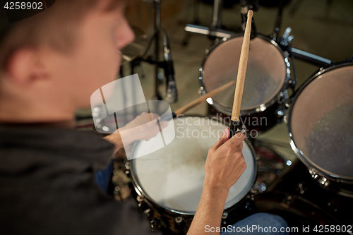 Image of man playing drums at concert or music studio