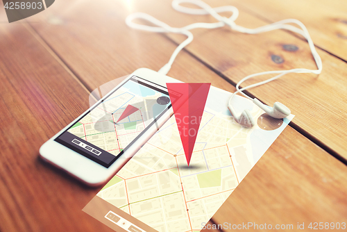 Image of close up of smartphone and earphones on wood