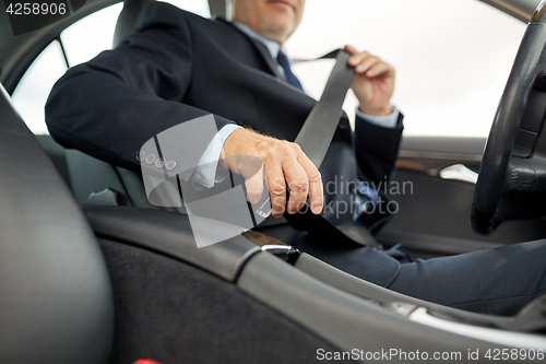 Image of senior businessman fastening car seat belt