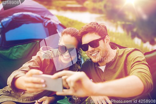 Image of couple of travelers taking selfie by smartphone