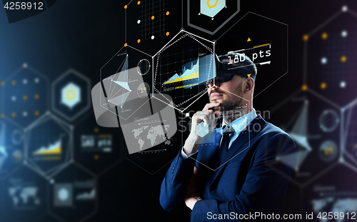 Image of businessman in virtual reality headset over black