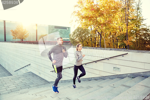 Image of happy couple running upstairs on city stairs