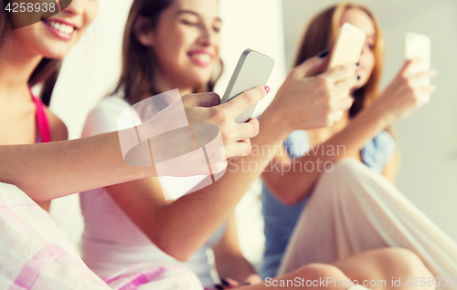 Image of friends or teen girls with smartphones at home