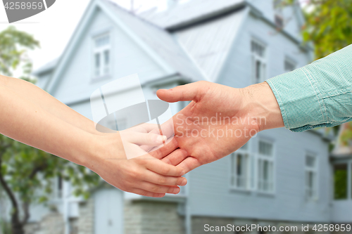 Image of father and child holding hands over house