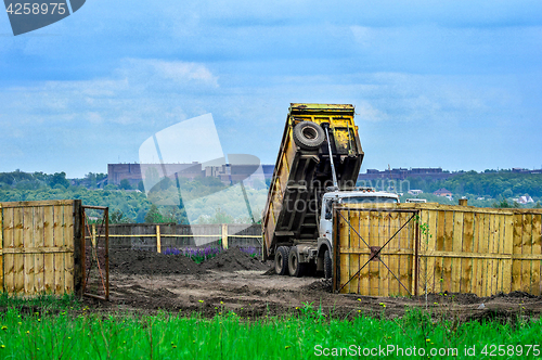 Image of The dumper brought and dumps earth in the open warehouse