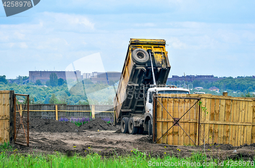 Image of The dumper brought and dumps earth in the open warehouse