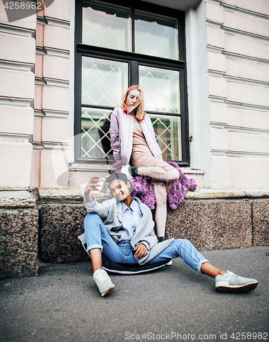 Image of Two teenage girls infront of university building smiling, having