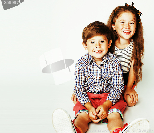 Image of little cute boy and girl hugging playing on white background, ha