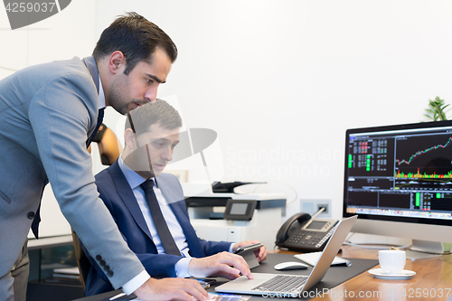 Image of Business team remotely solving a problem at business meeting using laptop computer and touchpad.