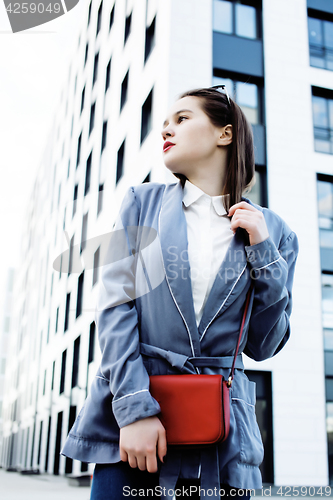 Image of young pretty brunette business woman posing against modern building, lifestyle people concept