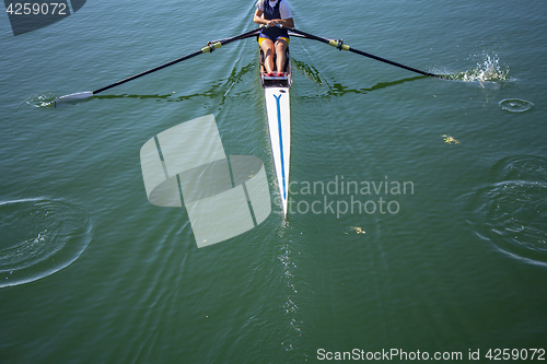 Image of A young girl rowing in boat on water