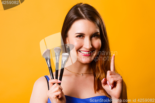 Image of Beautiful girl with makeup brushes