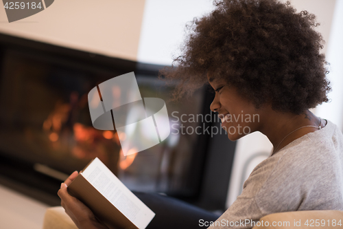 Image of black woman at home reading book