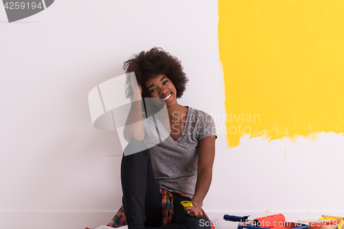 Image of back female painter sitting on floor