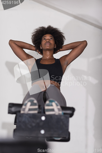 Image of black woman doing sit ups at the gym