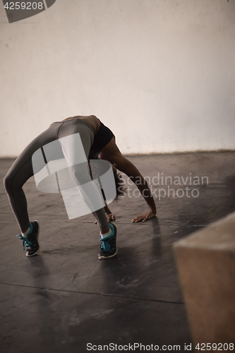 Image of black woman standing in bridge pose