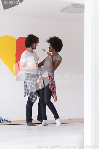 Image of couple with painted heart on wall