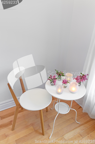 Image of Elegant white interior with candle lights and spring flowers