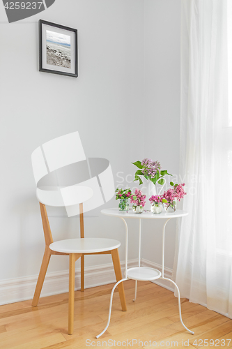 Image of White interior with modern furniture and spring flowers