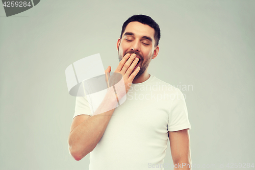 Image of yawning man over gray background