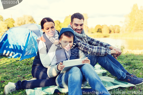 Image of happy family with tablet pc and tent at camp site