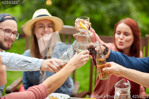 Image of happy friends with drinks at summer garden party