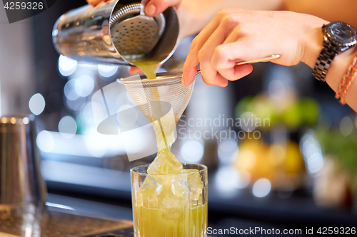 Image of close up of bartender preparing cocktail at bar