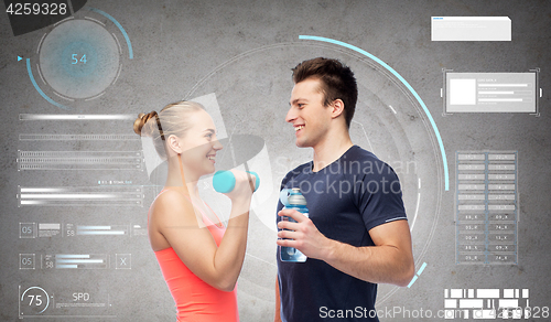 Image of sportive man and woman with dumbbell and water