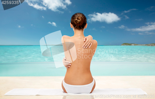 Image of beautiful topless woman with towel on summer beach