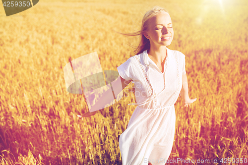 Image of smiling young woman in white dress on cereal field