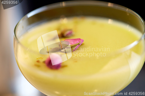 Image of close up of glass with creamy cocktail at bar