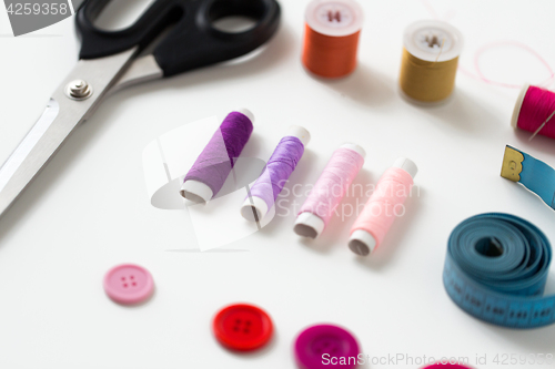 Image of scissors, sewing buttons, threads and tape measure