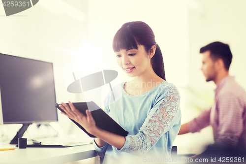 Image of happy creative female office worker with tablet pc