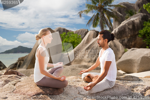 Image of happy couple doing yoga and meditating outdoors