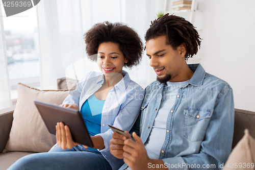 Image of couple with tablet pc and credit card at home