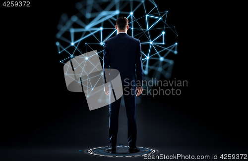 Image of businessman in suit from back over black