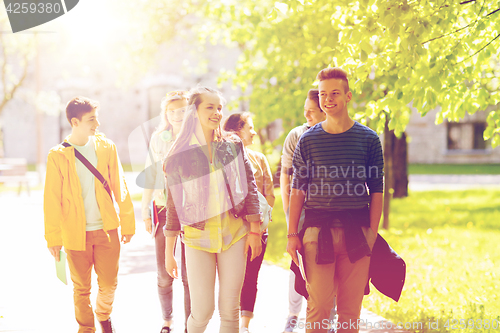 Image of group of happy teenage students walking outdoors
